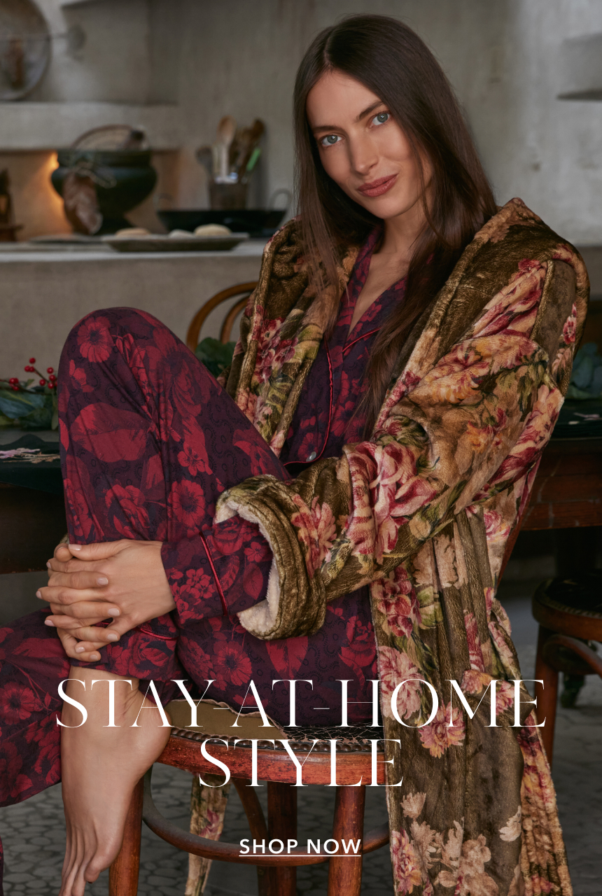 A model sitting and wearing PJs and a robe.