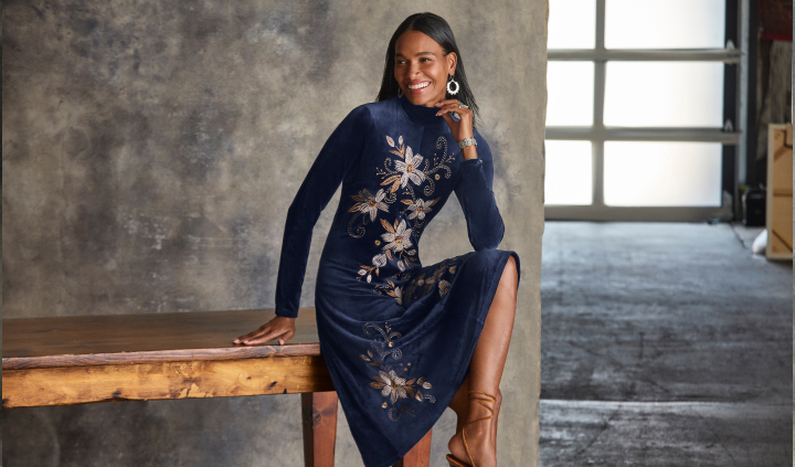 Model sitting wearing velvet dress with embroidery