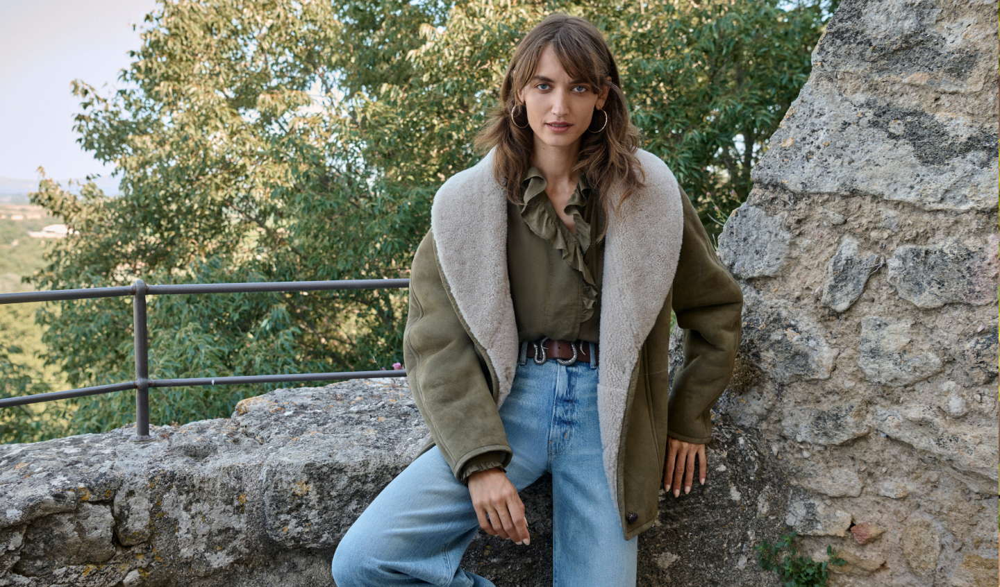 Model sitting wearing sueded jacket